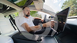 Caucasian man driving a modern electric car.