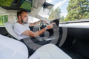 Caucasian man driving a modern electric car.