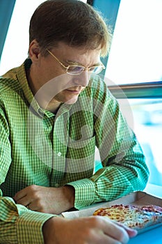 Caucasian man, early fifties, at airport cafe praying before meal