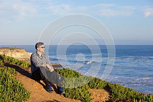 Caucasian man in early fifties sitting along ocean coast