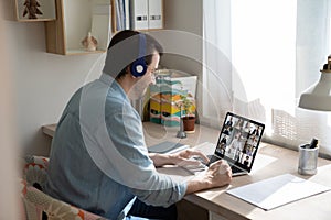 Caucasian man in earphones talk on video call with colleagues