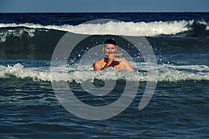 Caucasian man eating piece of watermelon in the sea water