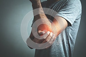 Caucasian man with elbow pain. Pain relief concept photo