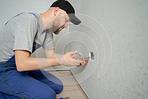 caucasian man electrician holding screwdriver working on the plug electric on residential electric system installing AC
