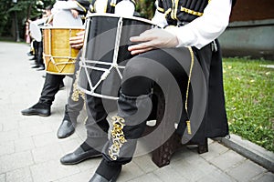 caucasian man in a ethnic costume sits on a chair and plays the drum . Drums of the peoples of the Caucasus photo