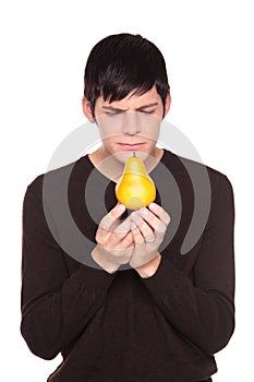 Caucasian man examining pear up close