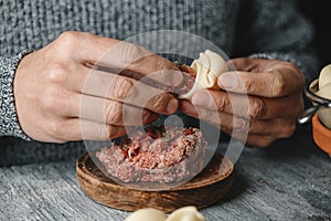 Man filling some Catalan galets with ground meat photo