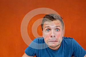 Caucasian man with funny face on red background