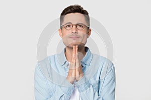 Caucasian man in glasses isolated hoping with prayer hands
