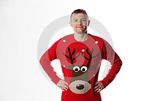 Caucasian man with hand on hips whilst wearing a christmas jumper