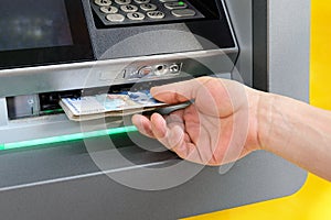 Caucasian man hand taking bulgarian levs from ATM. Receive money at a cash machine outdoors. ATM cash withdrawal