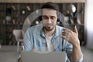 Caucasian man in headphones talk on video call on laptop