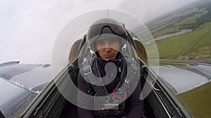 Caucasian man in a helmet - pilot of an gray training fighter plane flying and control yourself on the first real flight