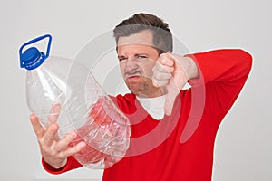 Caucasian man holding empty plastic bottle. Problem with frinking pure water.