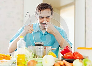 Caucasian man holding nose because of bad smell