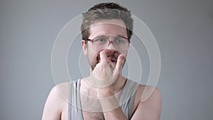 Caucasian man in huge glasses picking his nose