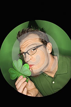 Caucasian man kissing shamrock.