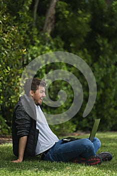 Caucasian man laughing while he is looking at his laptop