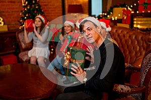 Caucasian man look question with surprise in gift box that exchange between member in family during Christmas holiday at home and