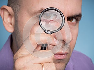 Caucasian man looking magnifying glass