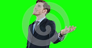 Caucasian man looking up and raising hand on green background