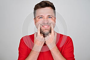 Caucasian man making an attempt to smile, try to hide bad negative mood.