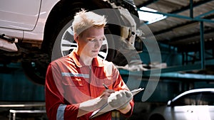 Caucasian man in mechanic suit Stand and write down list of repairs in the document. To prepare to repair and order spare parts,