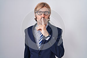 Caucasian man with mustache wearing business clothes asking to be quiet with finger on lips