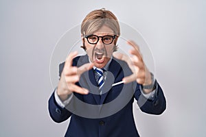 Caucasian man with mustache wearing business clothes shouting frustrated with rage, hands trying to strangle, yelling mad