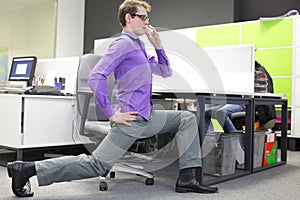 Caucasian man office worker with phone in hand, stretching legs