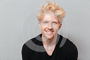 Caucasian man over grey wall near copyspace laughing