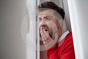 Caucasian man peeking through window being shocked with accident on street