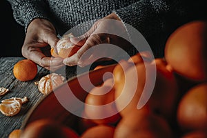 caucasian man peels a tangerine