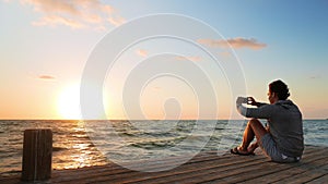 Caucasian Man Photographing Sunrise from the Wharf