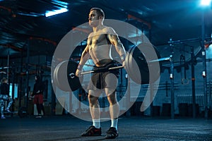 Caucasian man practicing in weightlifting in gym