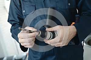 caucasian man putting a drill bit in a drill