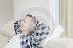 Caucasian man relaxing on sofa with headphones