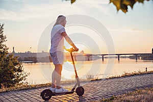 Caucasian man riding electric scooter at sunset