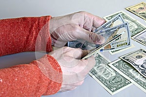 Caucasian man`s hands counting dollar banknotes