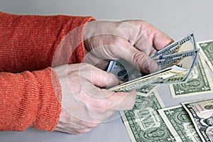 Caucasian man`s hands counting dollar banknotes