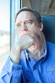 Caucasian man with serious thoughtful expression on train
