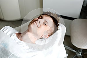 Caucasian man smiling on a massage bed, awaiting procedure