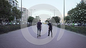 Caucasian man smoking with a friend and walking away in Spain