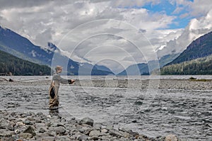 Caucasian man standing in the Ralph River fishing with the scenic landscape in the background