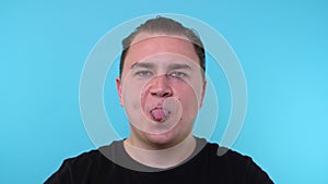 Caucasian man sticks out his tongue cut out on a blue background