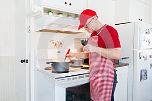 Caucasian man stirring food in a pot on the stove.