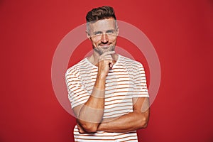 Caucasian man in striped t-shirt thinking and touching chin, iso