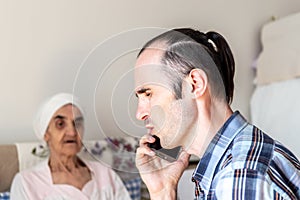 Caucasian man with stubbly beard talking and receiving bad news on the phone