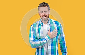 caucasian man suffering from heartache isolated on yellow background, copy space.