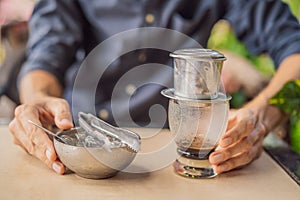 Caucasian man and traditional drip brewed Vietnamese coffee from a phin filter